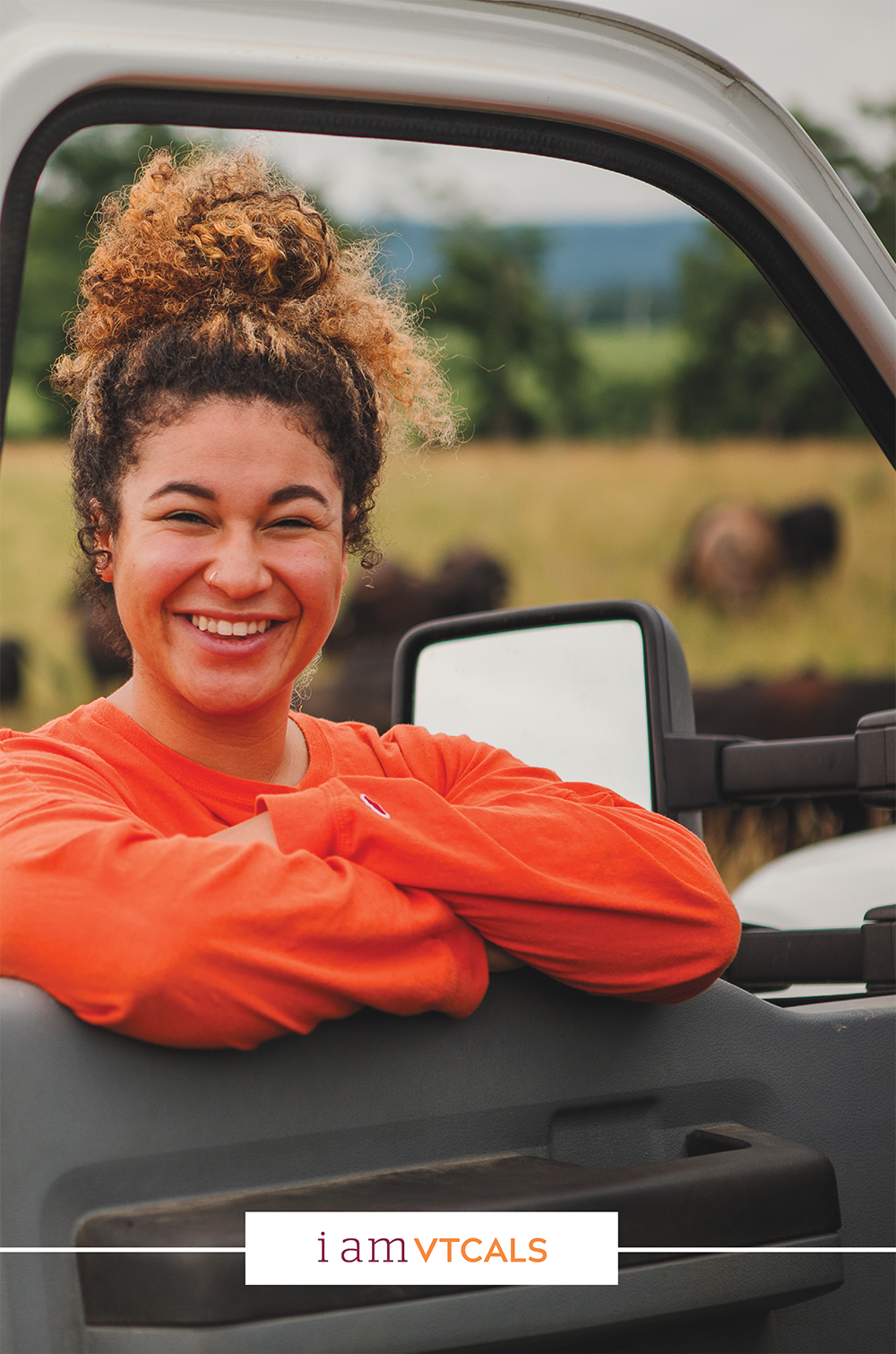 Image of a student smiling in the window of a truck door